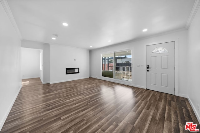 unfurnished living room featuring ornamental molding and dark hardwood / wood-style floors