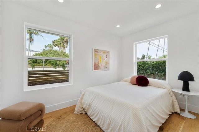 bedroom featuring hardwood / wood-style flooring and multiple windows