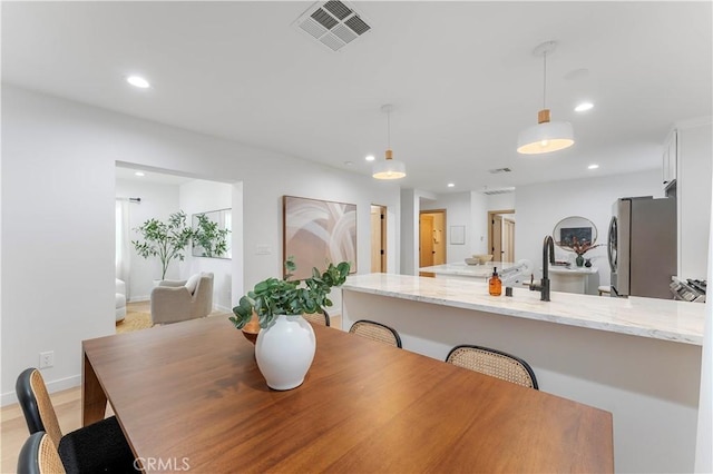 dining area with light hardwood / wood-style flooring and sink