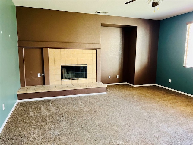 unfurnished living room featuring ceiling fan, a fireplace, and carpet