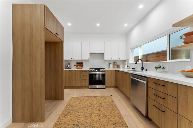 kitchen featuring light hardwood / wood-style floors, sink, stainless steel appliances, and white cabinets