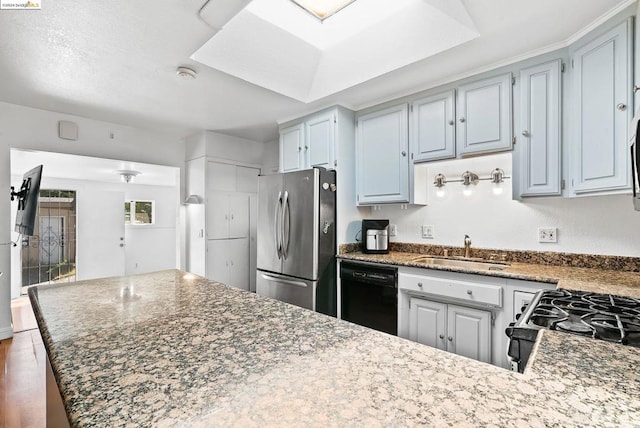 kitchen with dark hardwood / wood-style flooring, appliances with stainless steel finishes, sink, and light stone counters