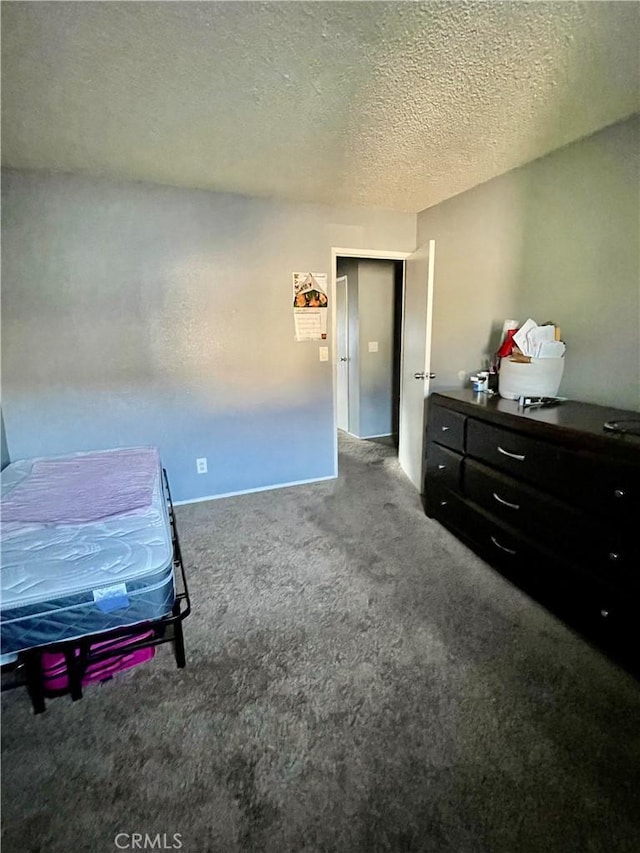 bedroom featuring carpet flooring and a textured ceiling