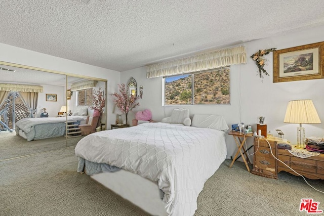 carpeted bedroom with a textured ceiling and a closet