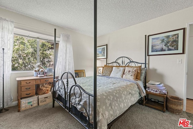 bedroom featuring a textured ceiling and carpet flooring