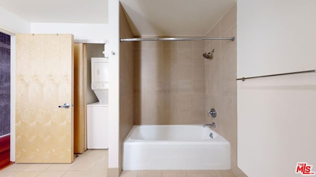 bathroom featuring tile patterned flooring, tiled shower / bath combo, and stacked washer and dryer