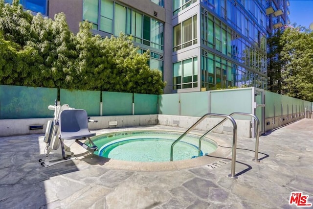 view of swimming pool featuring a hot tub