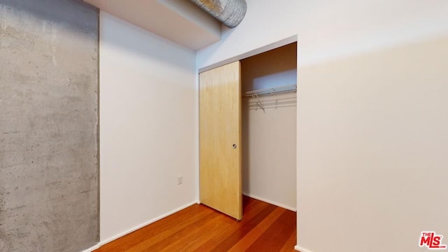 unfurnished bedroom featuring a closet and dark wood-type flooring