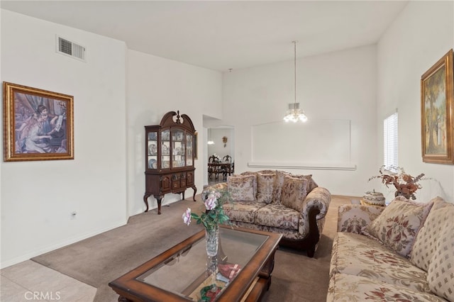 carpeted living room with a towering ceiling and a chandelier