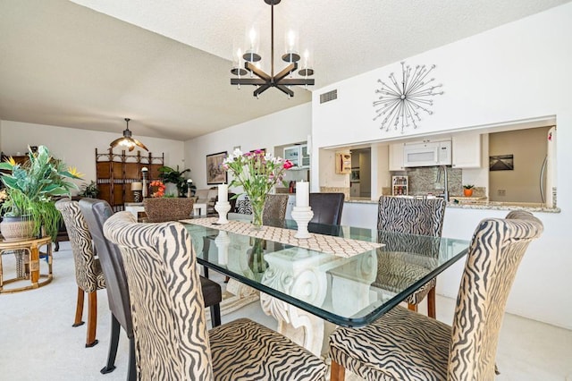 carpeted dining space featuring a chandelier and a textured ceiling