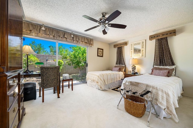 bedroom featuring light carpet, a textured ceiling, and ceiling fan