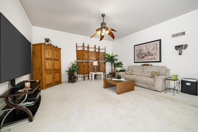 living room featuring carpet floors, a textured ceiling, and ceiling fan