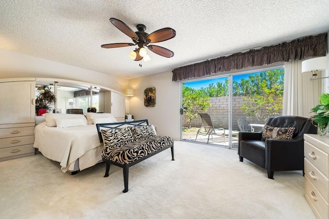 carpeted bedroom featuring multiple windows, access to outside, a textured ceiling, and ceiling fan