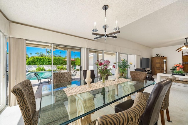 carpeted dining room with a notable chandelier and a textured ceiling