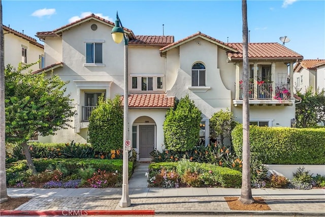 mediterranean / spanish-style home featuring a tile roof and stucco siding