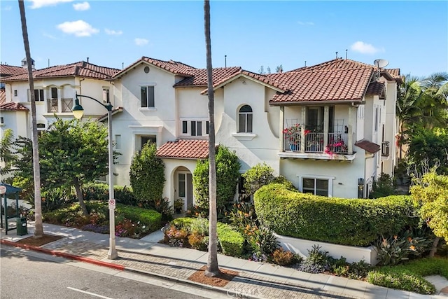 mediterranean / spanish house with a tile roof and stucco siding