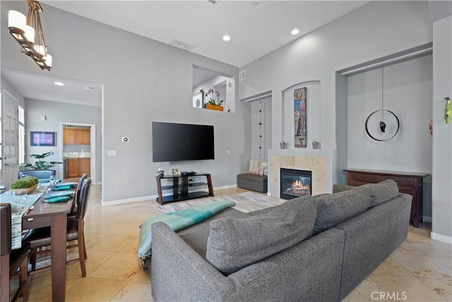 living area featuring baseboards, a fireplace, visible vents, and recessed lighting