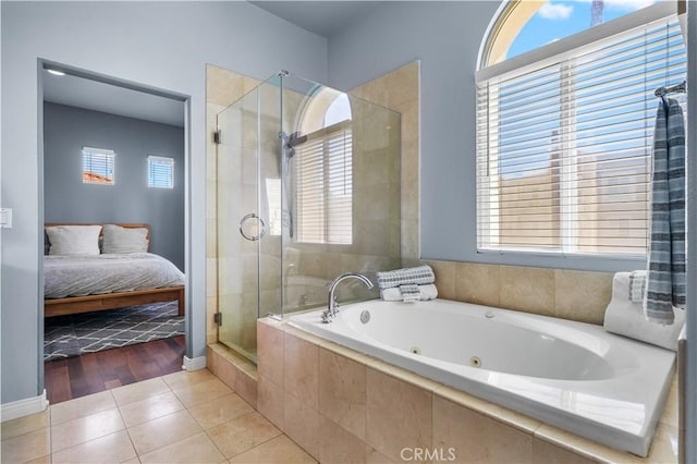 full bathroom with ensuite bath, plenty of natural light, tile patterned flooring, and a shower stall