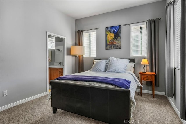 bedroom featuring a sink, carpet floors, ensuite bath, and baseboards