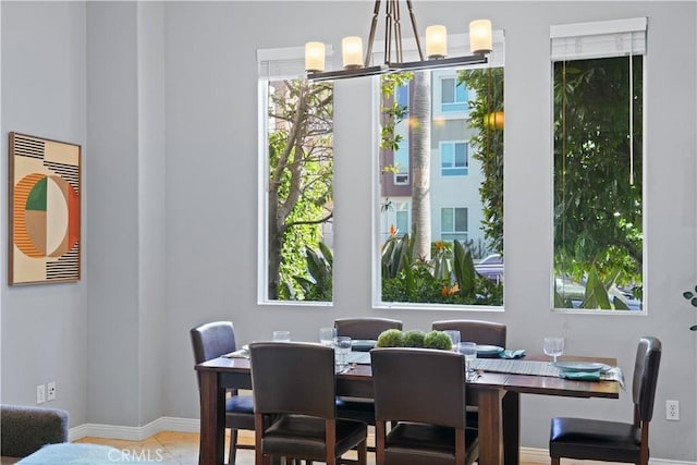 dining room with baseboards, tile patterned floors, and an inviting chandelier