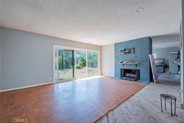 unfurnished living room with a textured ceiling and a brick fireplace