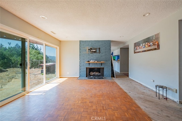 unfurnished living room with parquet floors, a textured ceiling, and a brick fireplace