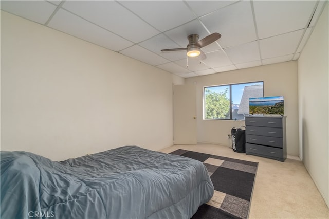 bedroom featuring a drop ceiling, ceiling fan, and light colored carpet