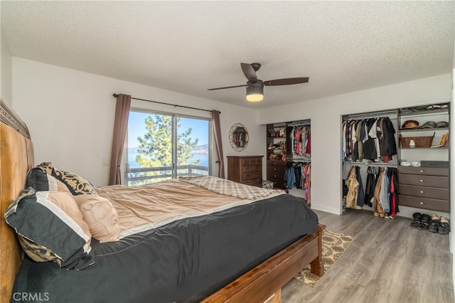 bedroom featuring hardwood / wood-style flooring, access to exterior, ceiling fan, and a textured ceiling