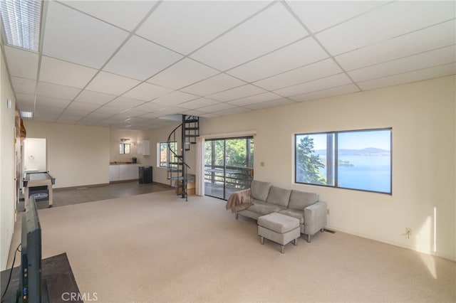 living area featuring a drop ceiling and carpet