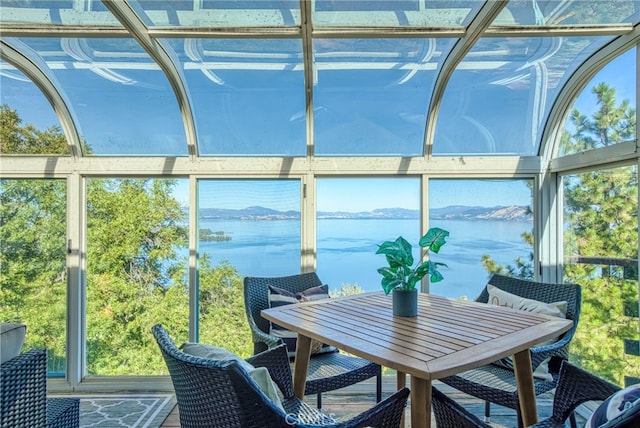 sunroom / solarium featuring a water view