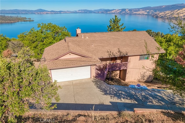 exterior space with a garage and a water and mountain view