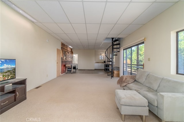 carpeted living room featuring a drop ceiling