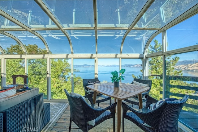 sunroom featuring a water view