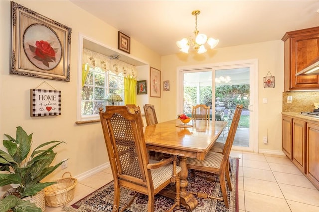 dining space featuring an inviting chandelier, light tile patterned flooring, and a healthy amount of sunlight