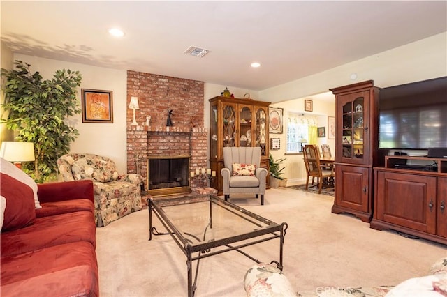 living room featuring a brick fireplace and light carpet