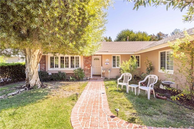 view of front of house with a front lawn and central AC