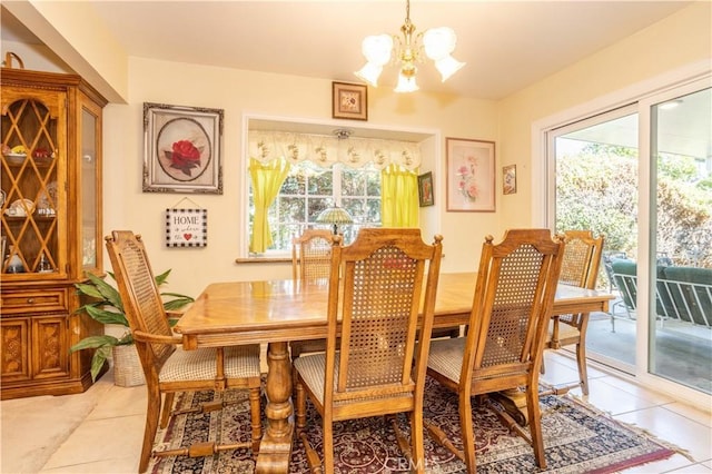 tiled dining space with a healthy amount of sunlight and a notable chandelier