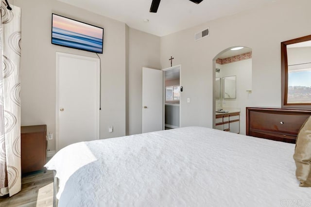 bedroom featuring connected bathroom, ceiling fan, and light wood-type flooring