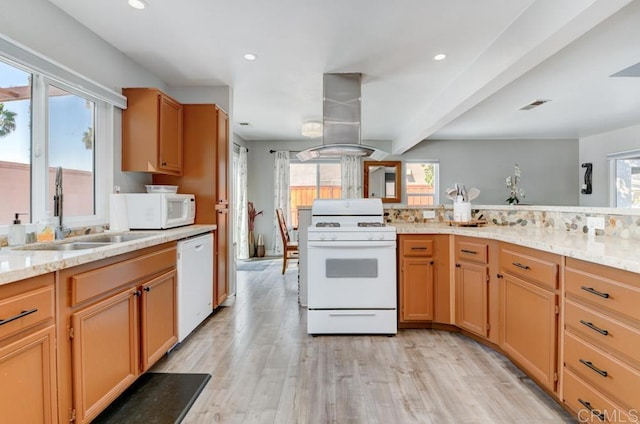 kitchen with island range hood, sink, light stone countertops, white appliances, and light hardwood / wood-style flooring