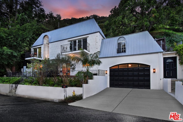 view of front of house featuring a garage and a balcony