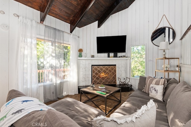 living room with a fireplace, wood ceiling, wooden walls, and a healthy amount of sunlight