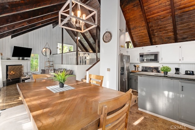 dining space featuring high vaulted ceiling, beam ceiling, an inviting chandelier, and wood ceiling