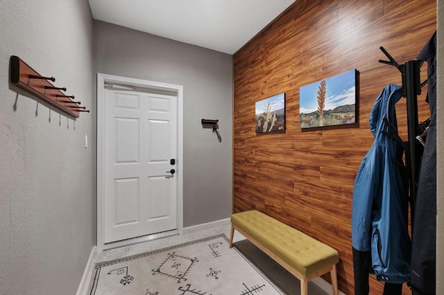 mudroom featuring wood walls