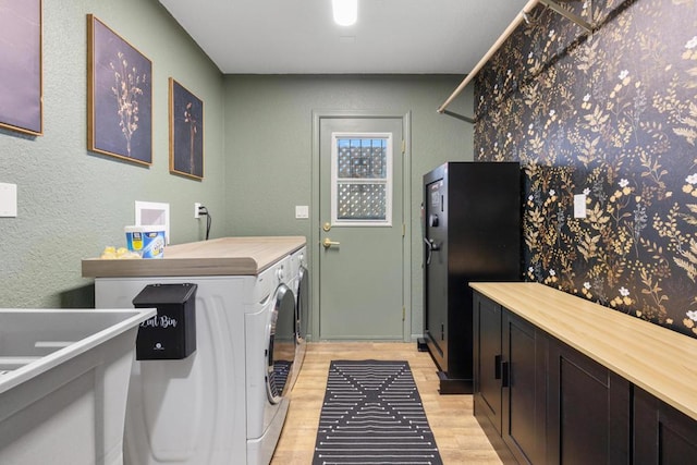 clothes washing area featuring washer and dryer and light wood-type flooring