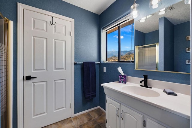 bathroom featuring tile patterned floors, vanity, a textured ceiling, and walk in shower