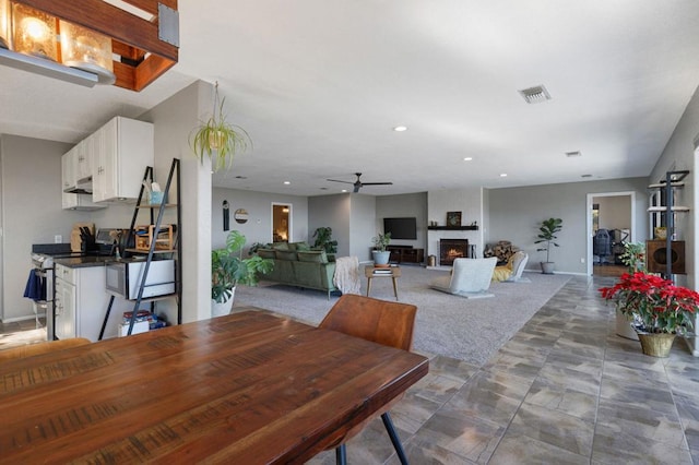 dining space featuring a fireplace and ceiling fan