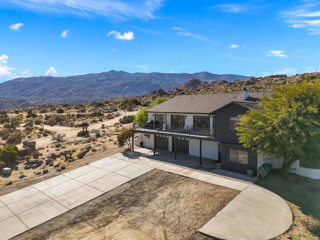 exterior space featuring a mountain view, a balcony, and a garage