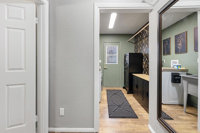 bathroom with washer / clothes dryer and wood-type flooring