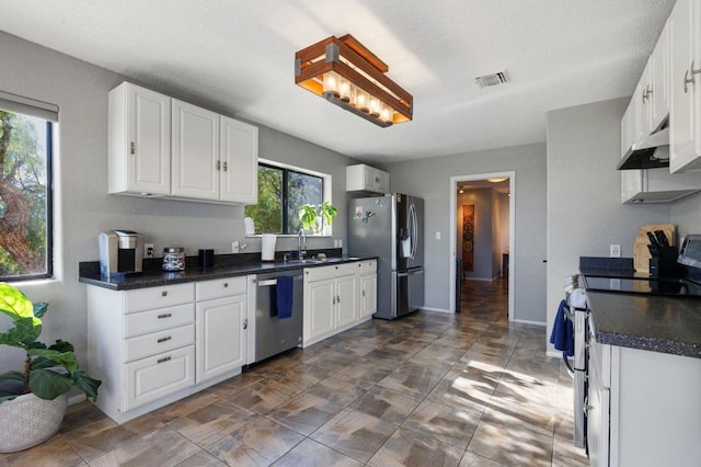 kitchen featuring plenty of natural light, white cabinetry, and appliances with stainless steel finishes