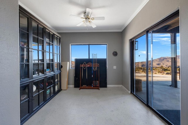 unfurnished room with a mountain view, ceiling fan, and crown molding